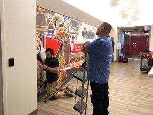 THE TEAM INSPECTS THE WALL GRAPHICS INSTALLATION