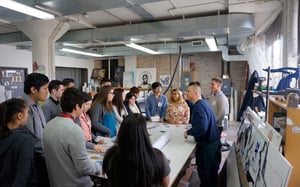 A group of people are standing around a table in a room .