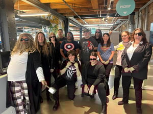 Cushing employees gather in the office wearing costumes reminiscent of action movies.