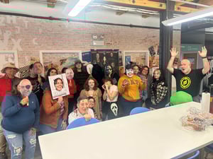 Cushing employees gather together in the office kitchen wearing costumes reminiscent of horror films.