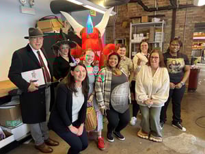 Cushing employees gather in the office wearing costumes reminiscent of fantasy genre films.