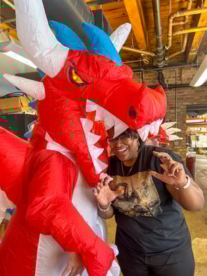 Sharika pretending to be eaten by a person wearing an inflatable dragon costumer for Animation Day.