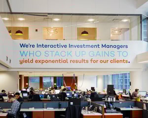 Company mission statement on a wall above various cubicles.